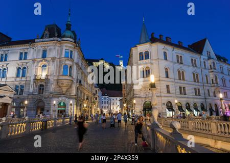 Ljubljana, Slowenien - 13. Juli 2022: Eintritt in die Altstadt der Hauptstadt bei Nacht, von der Dreifachbrücke aus gesehen. Stockfoto