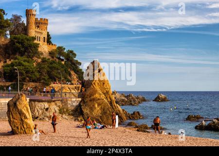 Lloret de Mar, Katalonien, Spanien - 5. Oktober 2016 - Menschen an einem Strand in einem malerischen Ferienort an der Costa Brava am Mittelmeer mit Blick auf Castell d Stockfoto