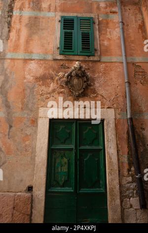 Kotor, 5. Juli 2021: Wunderschöne Straßen der Altstadt von Kotor, grüne alte Türen, Montenegro Stockfoto