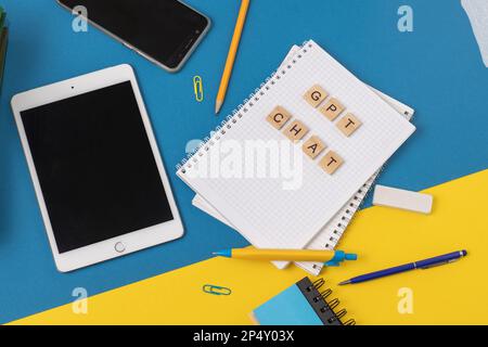 Arbeits- und Studienhintergrund mit Hilfe eines ChatGPT-bot. Wörter in Holzbuchstaben. Tischansicht mit freiem Notizbuchbereich. Chat-GPT zum Arbeiten und Erstellen. Ukraine, Kiew - 21. Februar 2023 Stockfoto