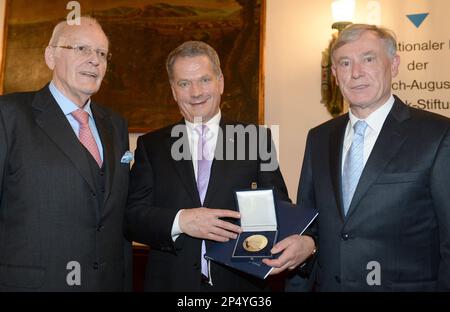 Finnish President Sauli Niinisto, center, holds the International Prize of the Hayek Foundation next to former German Presidents Roman Herzog, left, and Horst Koehler, right, in Freiburg, Germany, Sunday, Nov. 17, 2013. Niinisto had made outstanding contributions to the stability of public finances in Finland and the European Union, said former German President Horst Koehler at the awarding ceremony. (AP Photo/dpa, Patrick Seeger)
