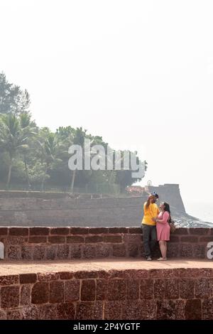 Candolim, Goa, Indien - Januar 2023: Ein indisches romantisches Paar macht ein Selfie an den Mauern der alten Küstenfestung in Sinquerim. Stockfoto