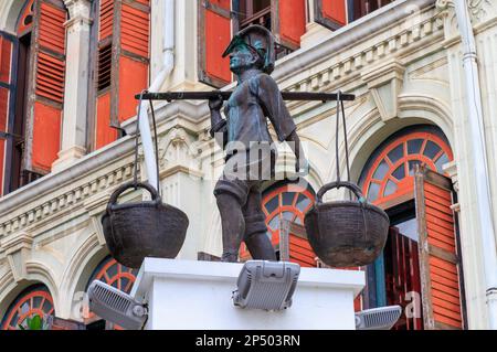 Bronzestatue eines Fischers, der Körbe an der Schulterstange in Smith Street, Chinatown, Singapur trägt Stockfoto