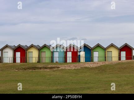 Eine Reihe farbenfroher hölzerner Strandhütten Stockfoto