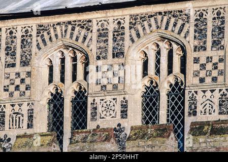 Mittelalterliche britische Kirchfassade, Details der Flushwork und karierten Feuersteindekoration rund um die Kirchenfenster der Woolpit Church in Suffolk, Großbritannien Stockfoto