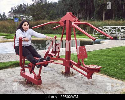 Aktive Frau: Sport auf öffentlichen Fitnessgeräten im Park Stockfoto