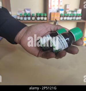 Nahaufnahme der homöopathischen Medizin, bestehend aus den Pillen und einer Flasche mit einer flüssigen homöopathischen Substanz Stockfoto