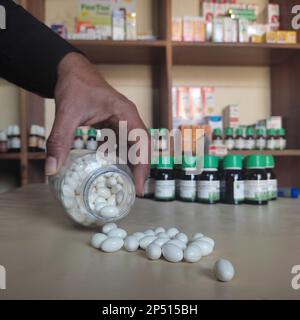 Nahaufnahme der homöopathischen Medizin, bestehend aus den Pillen und einer Flasche mit einer flüssigen homöopathischen Substanz Stockfoto