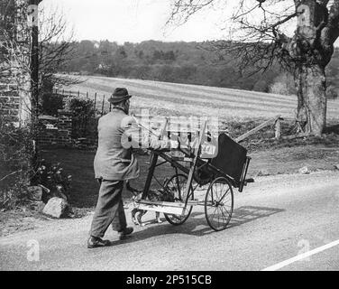 Ein ortskundiger Messerschleifer und sein Hund in einer Gasse in Surrey, England, machten 1970 (glaube ich). Stockfoto