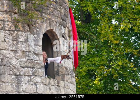 Luzarches, Frankreich - Oktober 12 2019: Falconer in einem Donjon mit ihrem Falken während des jährlichen "Médiévales" Festivals. Im Herbst, in vielen mittelalterlichen Jahren Stockfoto