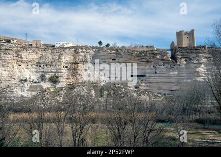 Ein Berg mit Fenstern, die Höhlen zeigen, die von Menschen bewohnt sind, und ein blauer Himmel mit kleinen Wolken. Stockfoto