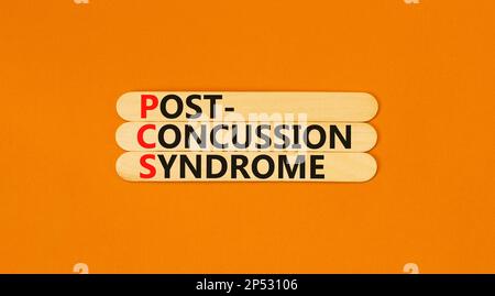 PCS-Postconcussion-Syndrom-Symbol. Konzeptbegriffe PCS-Postconcussion-Syndrom auf Holzstäbchen auf einem schönen orangefarbenen Tischhintergrund. Medizinisch Stockfoto