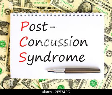 PCS-Postconcussion-Syndrom-Symbol. Konzeptbegriffe PCS-Postconcussion-Syndrom auf weißer Schrift auf einem schönen Hintergrund von Dollarnoten. Medizinische und Stockfoto