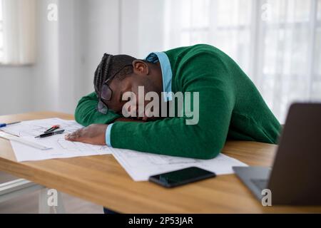 Afrikanischer Geschäftsmann, Der In Der Nähe Des Laptops Schläft, Müde Von Der Arbeit Im Büro Stockfoto