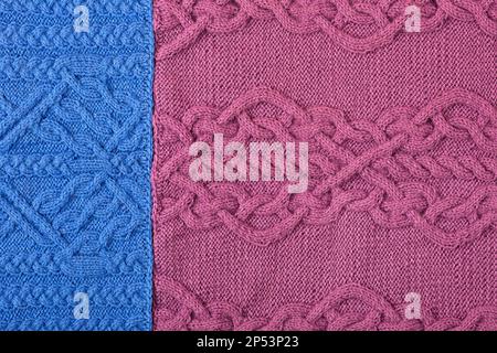 Blau gestrickt, lila Hintergrund. Großer Strickstoff mit Muster. Nahaufnahme einer Strickdecke. Stockfoto