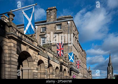 Union Jacks und Saltire Flaggen, die vor den City Chambers in der High Street, Edinburgh, Schottland, Großbritannien, fliegen. Stockfoto