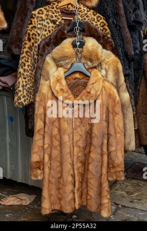 Warme Wintermäntel im Retro-Stil aus echtem Pelz, die auf dem Markt hängen Stockfoto