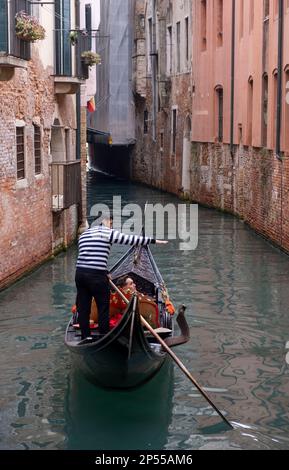 Gondoliere und Passagiere auf einem schmalen Seitenkanal, Viertel San Polo, Venedig, Italien Stockfoto