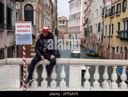 Gondolier sitzt auf einer Brücke im Viertel San Polo, Venedig, Italien Stockfoto