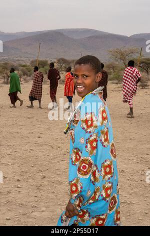 Karatu, Tansania - 16. Oktober 2022: Eine junge masai-Frau in traditionellem Outfit, tanzt und singt mit ihren Stammesangehörigen während einer Touristenshow Stockfoto