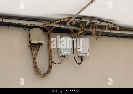 Ansichten einiger Kabelboxen, die die Internetverbindung und Telefonie durch Glasfaserkabel tragen, sichtbar auf der Straße mehrerer Unternehmen an einer Wand Stockfoto