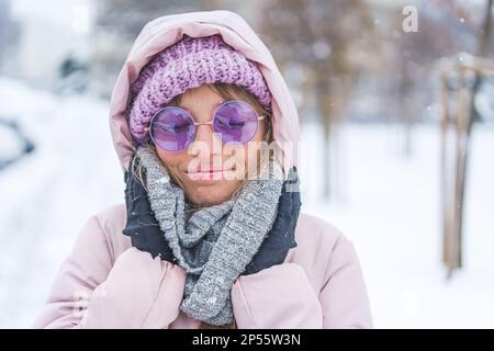 Mittellange Nahaufnahme einer jungen Frau, die warme Kleidung trägt und den kalten Wintertag genießt. Hochwertiges Foto Stockfoto