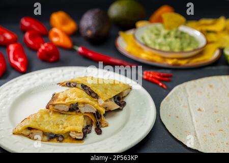 Quesadilla mit Hühnerfleisch und Bohnen und Guacamole mit Nachos Stockfoto