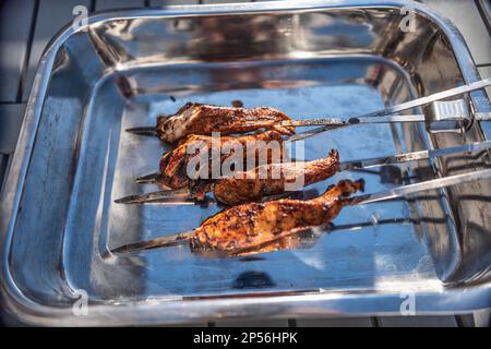 Grillspieße mit mariniertem Hühnchen in einer Metallschüssel. Stockfoto