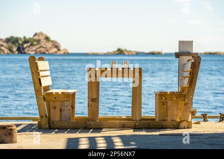 Zwei Tassen auf einem Tisch bei Bänken am Meer Stockfoto