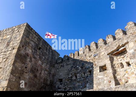 Surami Festung alte Steinmauern mit Zinnen, georgische Nationalflagge oben, Georgien. Stockfoto