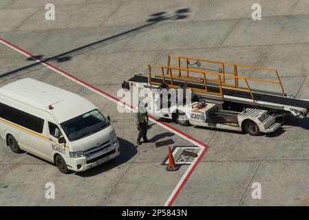 Kapstadt, Südafrika. 2023. Fahrzeug zur Verladung von Gepäck und Gepäck in ein Flugzeug auf dem Vorfeld. Stockfoto