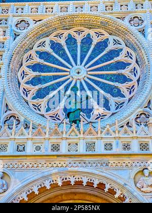Fassade der Kathedrale von Monza mit Statue von St. Johannes der Täufer und ein großes Rosenfenster, Italien Stockfoto