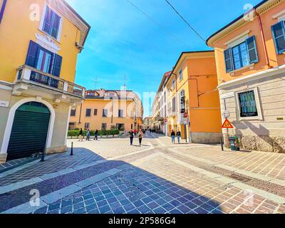 MONZA, ITALIEN - 11. APRIL 2022: Gehen Sie entlang der engen Via Carlo Alberto, vorbei an kleinen Stadthäusern der mittelalterlichen Stadt, am 11. April in Monza, Italien Stockfoto