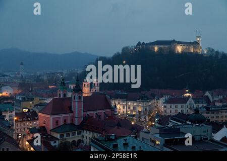 Ljubljana, Slowenien - April 10 2019: Luftaufnahme während einer nebligen Nacht des Schlosses Ljubljana und der Franziskanerkirche der Verkündigung. Stockfoto