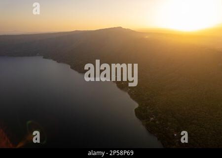 Sonnenuntergang über dem Apoyo-See in Nicaragua aus der Vogelperspektive. Grüne Lagune am Ufer Stockfoto