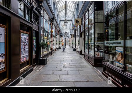 Älterer Gentleman im Anzug, der nach Schließung im Sommer durch die historische Morgan Arcade spaziert Stockfoto