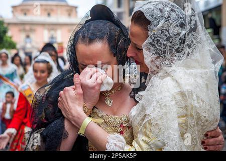 Nachdem sie die Jungfrau gesehen hatten, weinten Frauen in Fallera-Kostümen während der Blumenparade, zu Ehren von 'Virgen de los desamparados', Fallas-Festival, Pla Stockfoto