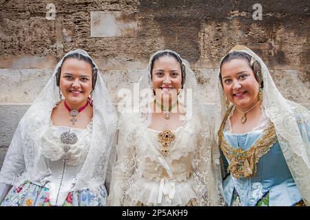 Frauen in Fallera-Kostümen während der Blumenparade, zu Ehren der 'Virgen de los desamparados', Fallas-Festival, Plaza de la Virgen Square, Valencia Stockfoto