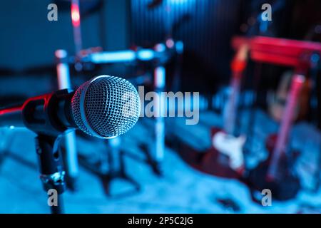 Modernes Mikrofon im Aufnahmestudio in Farbtönen. Musikband-Training Stockfoto