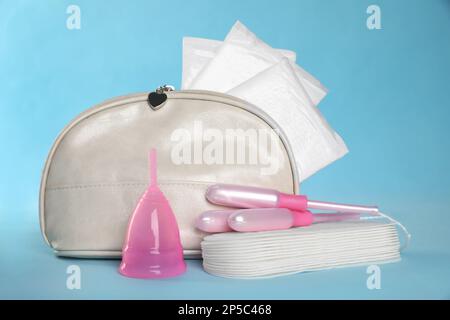 Beutel mit Menstruationseinlagen und anderen Hygieneprodukten auf hellblauem Hintergrund Stockfoto