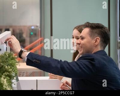 Geschäftsmann Geschäftsfrau Porträt junger Erwachsener klug attraktiv schön schön sitzen mit dem Finger fröhliches Gespräch Gesprächsteam Unternehmen p Stockfoto