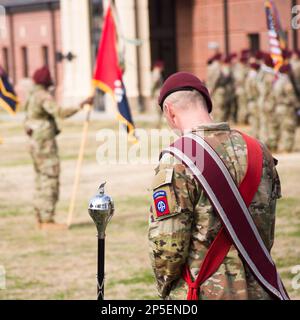 Master-Musiker, Fort Bragg, mit abgesenktem Kopf neben dem Zeremonieteam. Soldaten und Flaggen im Hintergrund vor der Halle der Helden. Stockfoto