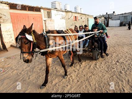 Gaza, Palästina. 06. März 2023. Louay Abu Sahloul, 33, transportiert Kinder mit einem Eselskart zum Kindergarten für 5 Schekel (1,4 US-Dollar) pro Monat in Khan Yunis, im südlichen Gazastreifen. Kredit: SOPA Images Limited/Alamy Live News Stockfoto