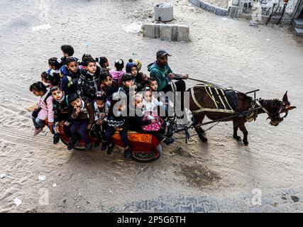 Gaza, Palästina. 06. März 2023. Louay Abu Sahloul transportiert Kinder zu einem Preis von 5 Schekel (1,4 US-Dollar) pro Monat in Khan Yunis, im südlichen Gazastreifen, mit einem Eselwagen in einen Kindergarten. Kredit: SOPA Images Limited/Alamy Live News Stockfoto