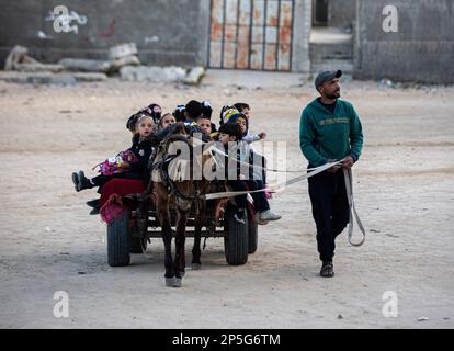 Gaza, Palästina. 06. März 2023. Louay Abu Sahloul transportiert Kinder zu einem Preis von 5 Schekel (1,4 US-Dollar) pro Monat in Khan Yunis, im südlichen Gazastreifen, mit einem Eselwagen in einen Kindergarten. Kredit: SOPA Images Limited/Alamy Live News Stockfoto