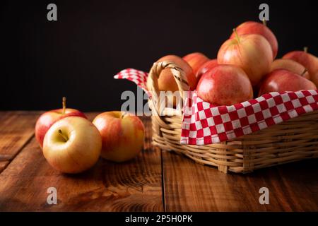 Mehrere königliche Gala-Äpfel (Malus domestica) auf einem rustikalen Holztisch. Apfelbäume werden weltweit angebaut und sind die am weitesten verbreitete Art des g. Stockfoto