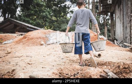 Arme Kinder, die auf der Baustelle gegen Kinderarbeit arbeiten, Kinder müssen wegen Armut arbeiten, Welttag gegen Kinderarbeit und tra Stockfoto