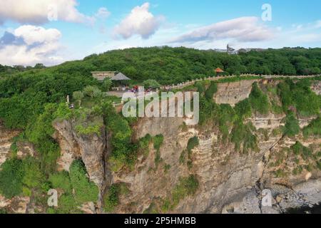 Panoramaaufnahme des spektakulären Tempelkomplexes Pura Luhur in Uluwau auf Bali entlang der majestätischen, grün bedeckten Klippen, die ins Meer fließen. Stockfoto