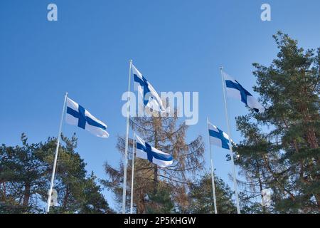 Fünf finnische Nationalflaggen im Wind gegen den blauen Himmel Stockfoto