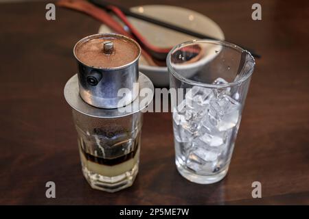 Traditioneller vietnamesischer, dunkel gerösteter Tropfkaffee mit Kondensmilch, Ca Phe Sua Da in einem Café-Restaurant Stockfoto